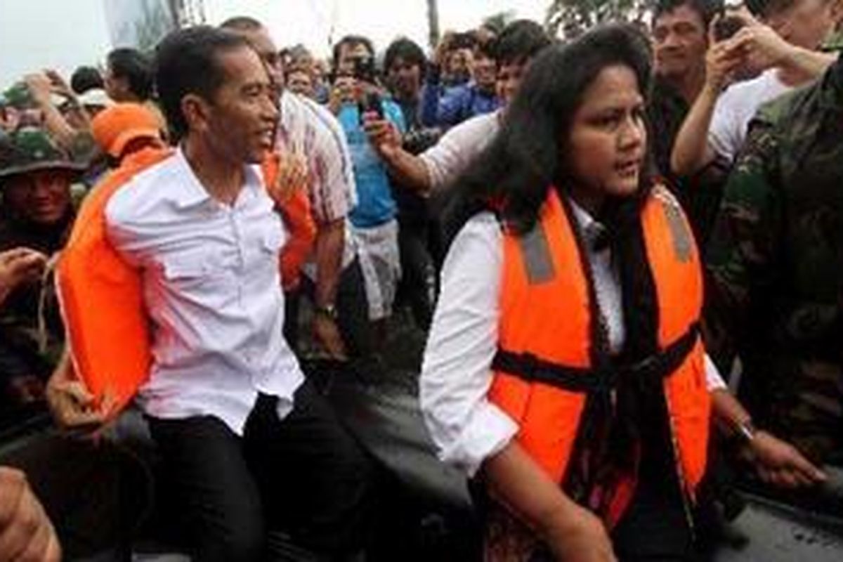 Gubernur DKI Jakarta, Joko Widodo (kiri), meninjau korban banjir di kawasan perumahan mewah Pluit, Jakarta Utara, Sabtu (19/1/2013). Banjir bandang menutup seluruh kawasan Pluit dengan ketinggian lebih dari 2 meter diakibatkan Waduk Pluit yang meluap.  
