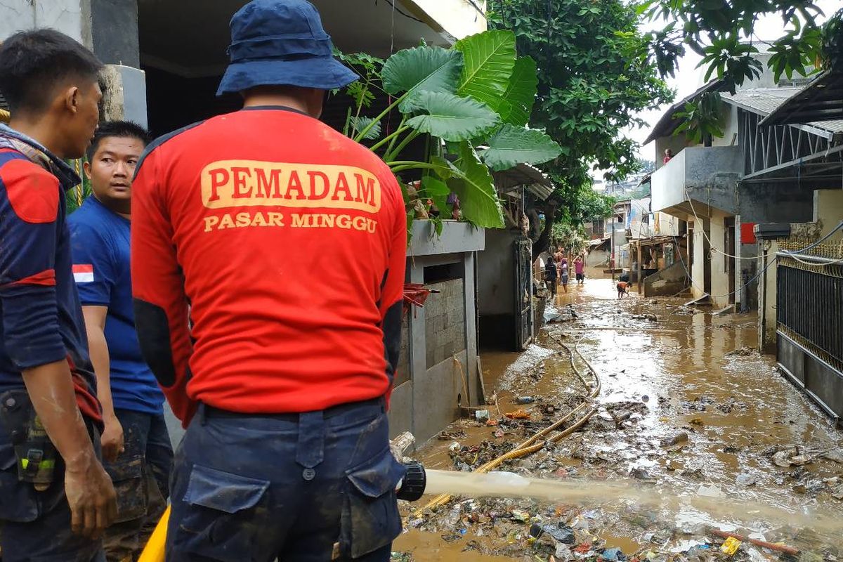 Petugas pemadam kebakaran mulai membersihkan lumpur di wilayah terdampak banjir di Pejaten Timur, Jakarta Selatan Jumat (26/4/2019).