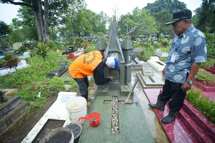 Petugas sedang memperbaiki nisan makam di TPU Giri Darmoloyo yang diduga dirusak orang tidak dikenal, Jumat (4/1/2019). Polisi tengah menyelidiki kasus ini.