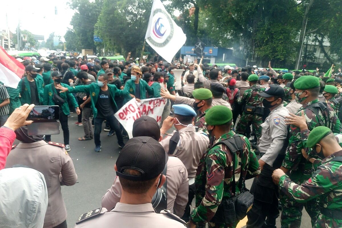 Massa mahasiswa di Bogor terlibat aksi saling dorong dengan aparat kepolisian saat menggelar unjuk rasa menolak pengesahan Undang-undang Cipta Kerja di depan Istana Bogor, Kamis (8/10/2020).