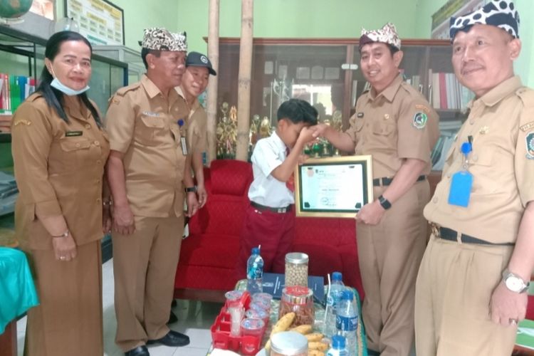 Dinas Pendidikan Banyuwangi saat menyerahkan sertifikat penghargaan kepada Farel Prayoga 