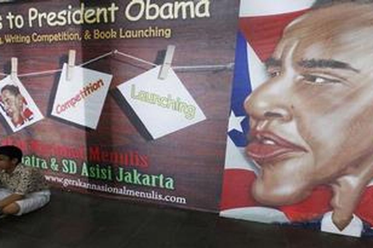 A student from Asisi Catholic School, the former elementary school of U.S. President Barack Obama, sits in front of a poster of him during the book launch of "Message to President Obama" by Indonesian writer Damien Dematra in Jakarta, November 3, 2010. Obama remains popular in the worlds most populous Muslim country, where he spent four years while growing up. He will visit Indonesia next week as part of his a 10-day trip to India, Indonesia, South Korea and Japan.