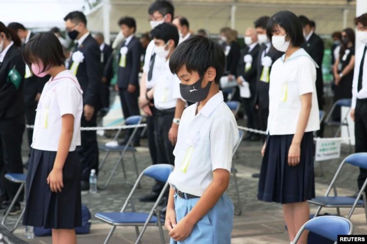 Warga menjaga jarak sosial saat mengheningkan cipta untuk menghormati para korban bom atom 1945 dalam upacara peringatan 76 tahun pengeboman di Nagasaki, di Taman Perdamaian Nagasaki di Nagasaki, Jepang, 9 Agustus 2021.
