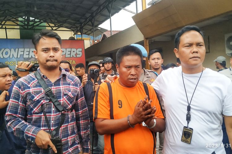 Tersangka perkosaan dan pembunuhan R alias E dikawal dua anggota Sat Reskrim Polres Sukabumi Kota di Sukabumi, Jawa Barat, Selasa (31/1/2023).