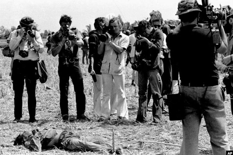 Wartawan memotret tubuh di daerah Saigon pada awal 1968, selama Serangan Tet.