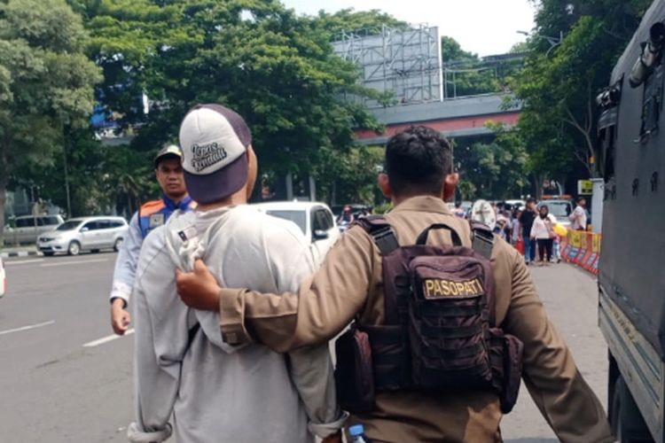 Anggota Satpol PP Surabaya saat menangkap juru parkir liar di Kebun Binatang Surabaya, Jawa Timur, Rabu (27/12/2023).