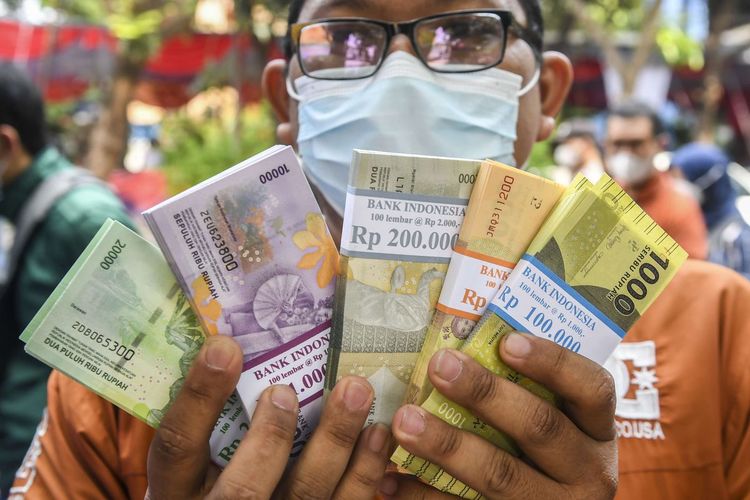 Ilustrasi warga menunjukan uang baru usai ditukarkan di mobil kas keliling Bank Indonesia (BI). Simak lokasi penukaran uang baru di kas keliling dan titik perbankan di wilayah DI Yogyakarta selama bulan Ramadhan 2024