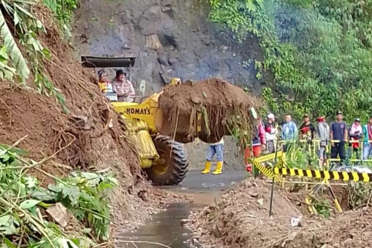 Alat berat tengah berupaya membersihkan material longsor yang menutup badan jalan penghubung Cianjur - Bandung lintas selatan, Rabu (16/11/2022)