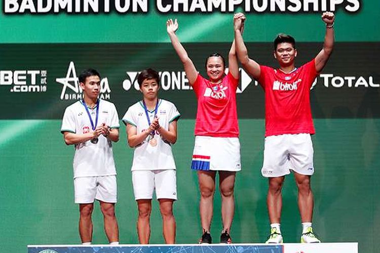 Pebulu tangkis ganda campuran Indonesia Praveen Jordan dan Melati Daeva Oktavianti mengangkat tangan di podium usai memenangi laga final ganda campuran All England melawan pebulu tangkis Thailand Dechapol Puavaranukroh dan Sapsiree Taerattanachai di Arena Birmingham, Inggris, Minggu (15/3/2020). Praveen/Melati berhasil menjadi juara All England setelah memenangi pertandingan dengan skor 21-15, 17-21, dan 21-8.