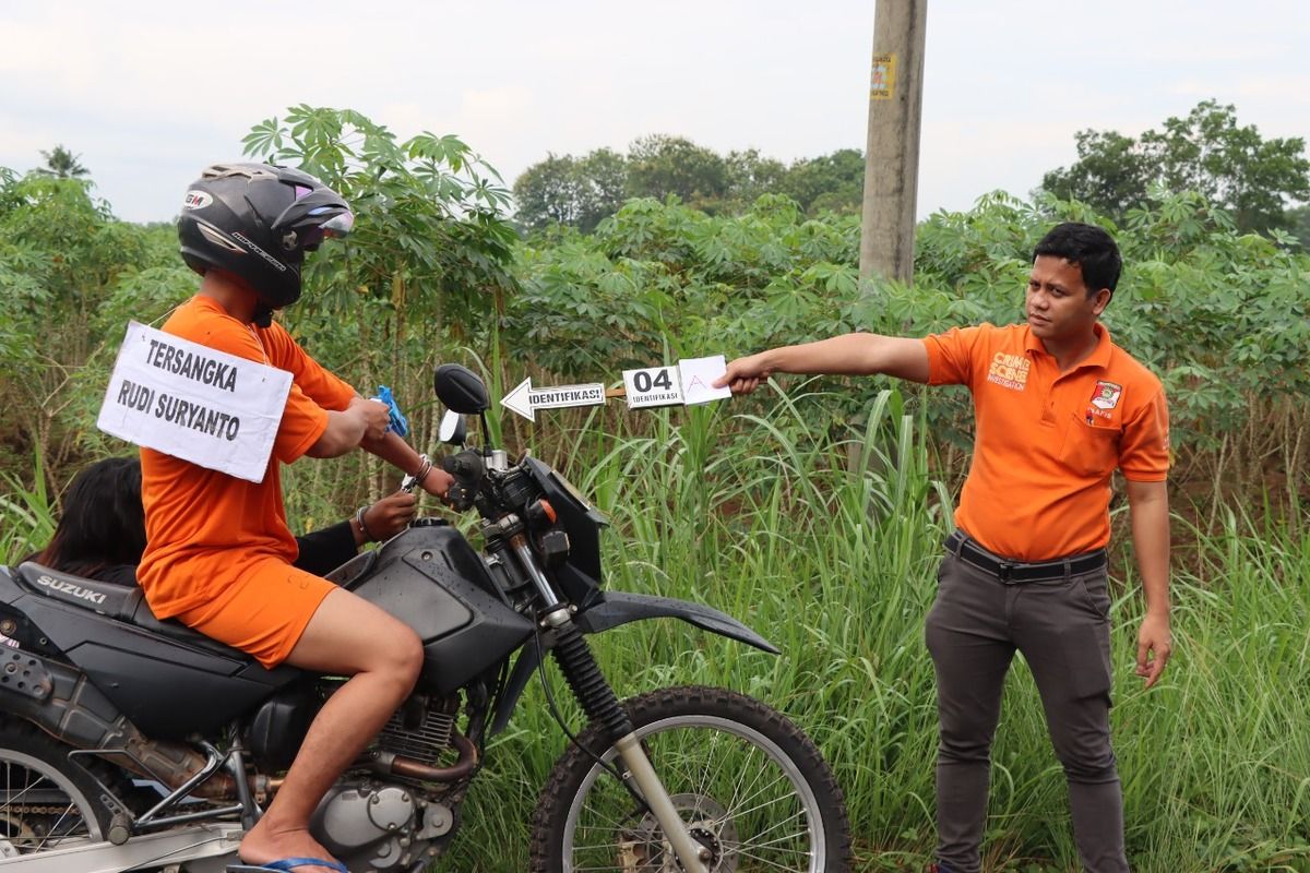 Tersangka Aipda Rudi (PS Kanit Provost Polsek Way Pengubuan) saat menjalani adegan pengujian senjata api sebelum tiba di rumah korban, Aipda Ahmad Karnain, Selasa (6/9/2022). Aipda Rudi kini dikenakan Pasal 340 KUHP tentang Pembunuhan Berencana.