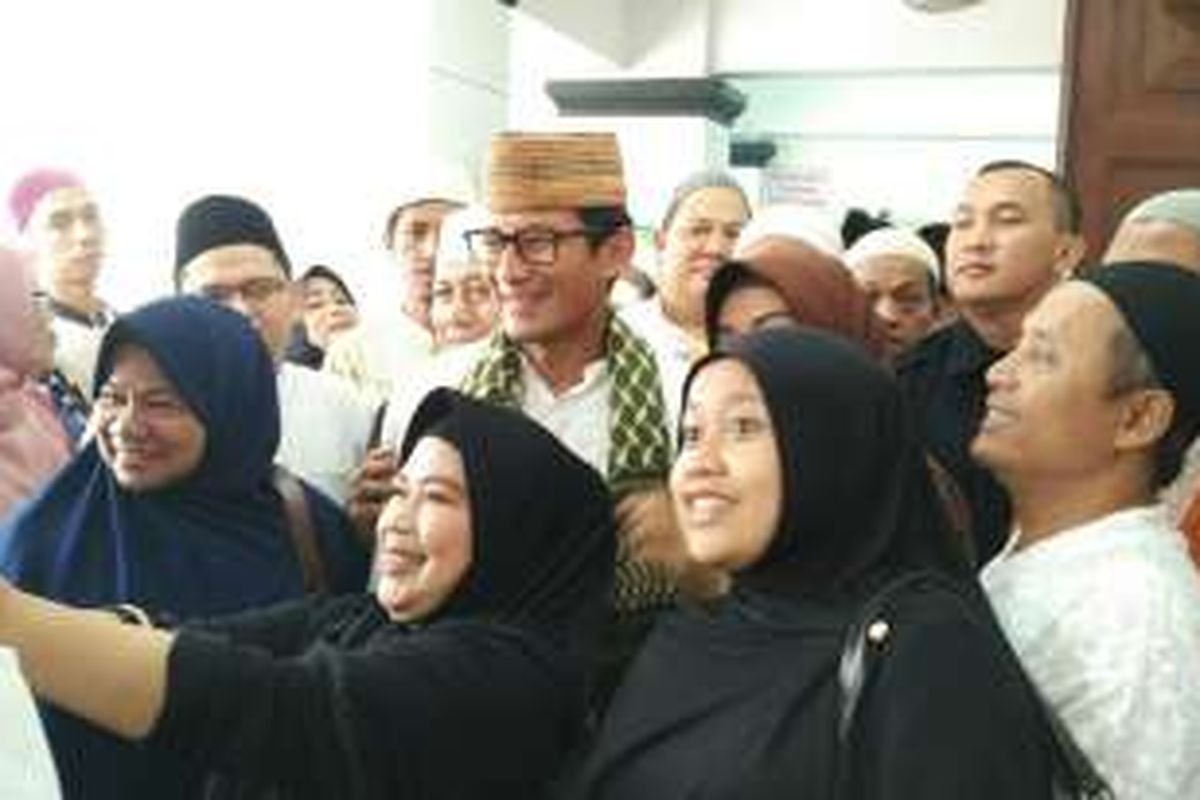 Calon wakil gubernur DKI Jakarta Sandiaga Uno diajak foto bersama seusai berziarah ke makam Habib Ali Kwitang di Kwitang, Senen, Jakarta Pusat, Minggu (30/10/2016).