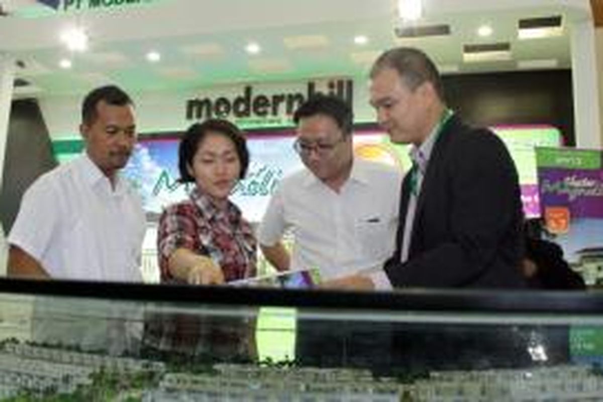 General Manager Operasional PT Modernland Realty Tbk, Kelvin Octavianus  (kedua kanan) dan Advertising and Promotion Manager, Gunawan Setyo Hadi (kiri) menjelaskan tentang maket Modernhill kepada pengunjung Indonesia Property Expo 2013 di Jakarta Convention Center, Minggu, (25/8/2013). Hingga Agustus 2013 Modernhill telah dibangun sebanyak 1.500 unit.  