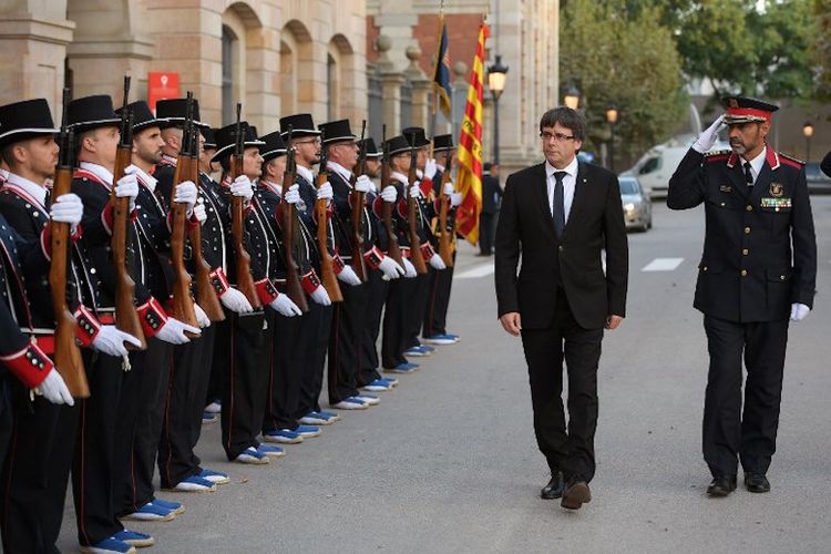 Dokumen foto ini diambil pada 10 September 2017. Presiden Catalonia Carles Puigdemont (dua dari kanan) dan Josep Lluis Trapero (kanan), Kepala Kepolisian Catalonia, menggelar inspeksi terhadap pasukan Mossos DEsquadra sebelum menghadiri seremoni penghargaan terhadap kepolisian Catalonia yang biasa disebut Mossos dEsquadra. 