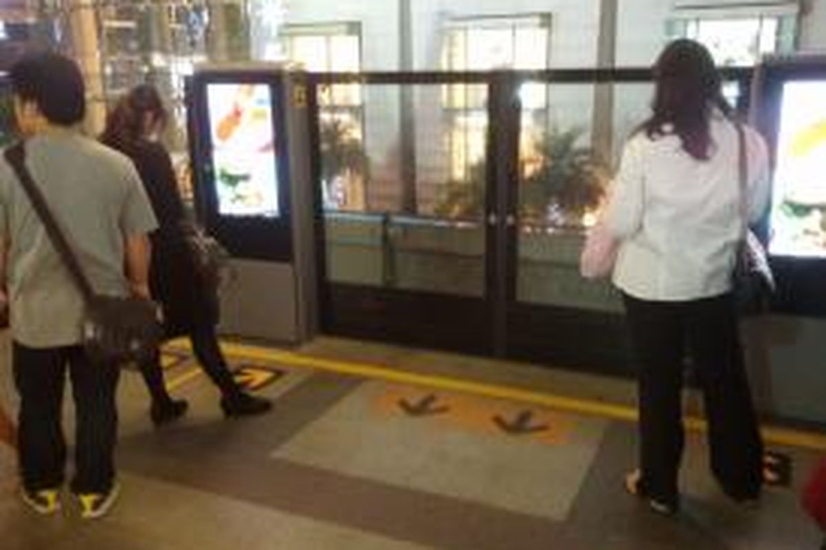 Sejumlah calon penumpang Bangkok Transit System (BTS) yang sedang menunggu kedatangan kereta di stasiun. Terlihat simbol anak panah penanda agar penumpang yang hendak masuk mendahulukan terlebih dahulu penumpang yang hendak keluar.