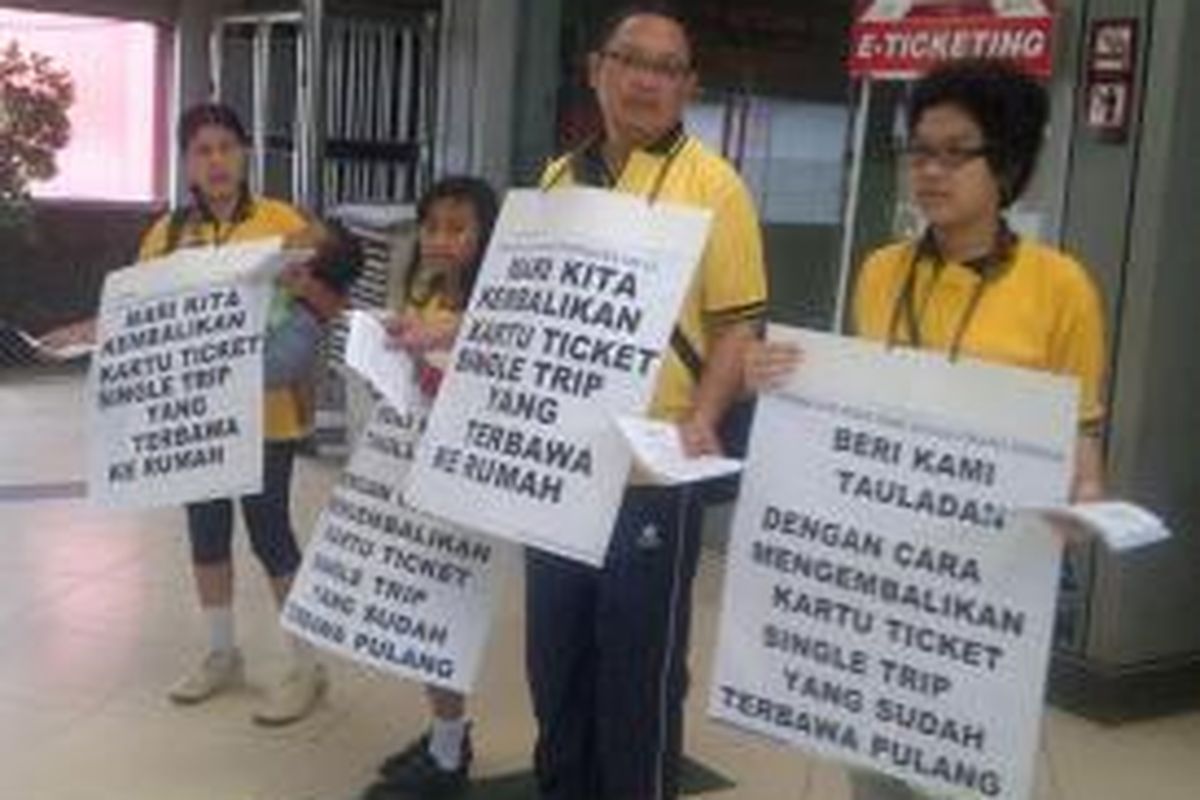 Widyatmoko dan keluarganya saat melakukan aksi mengajak masyarakat mengembalikan kartu single trip yang telah dibawa pulang ke PT KAI di Stasiun Sudirman, Jakarta Pusat, Minggu (14/7/2013)