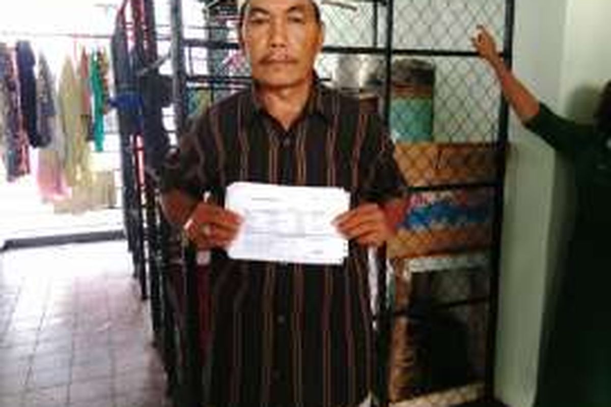 Bambang (61) eks warga Pasar Ikan di Rusun Rawa Bebek menunjukan bukti pembelian listrik dari pengelola. Kamis (9/6/2016)
