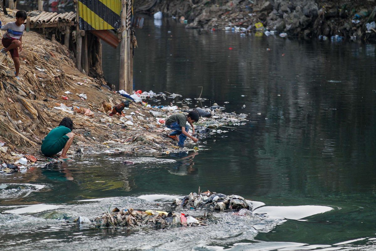 Warga beraktivitas di pemukiman padat penduduk di bantaran Sungai Ciliwung, Manggarai, Jakarta, Minggu (28/7/2019). 