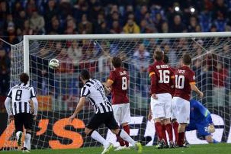 Striker Juventus, Carlos Tevez, seusai melepaskan tendangan yang berujung gol ke gawang AS Roma, pada lanjutan Serie-A, di Stadion Olimpico, Senin (2/3/2015). 