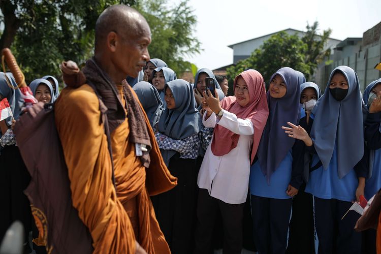 Antusias warga menyambut biksu yang melintas menjalani ritual thudong saat perjalanan dari Kota Tegal ke Pemalang, Jawa Tengah, Rabu (24/5/2023). Sebanyak 32 biksu jalan kaki dari Thailand menuju Candi Borobudur untuk meyambut Hari Raya Waisak.