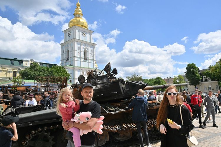 Warga melintasi pameran perlengkapan rusak militer Rusia di pusat kota Kyiv, 28 Mei 2022.