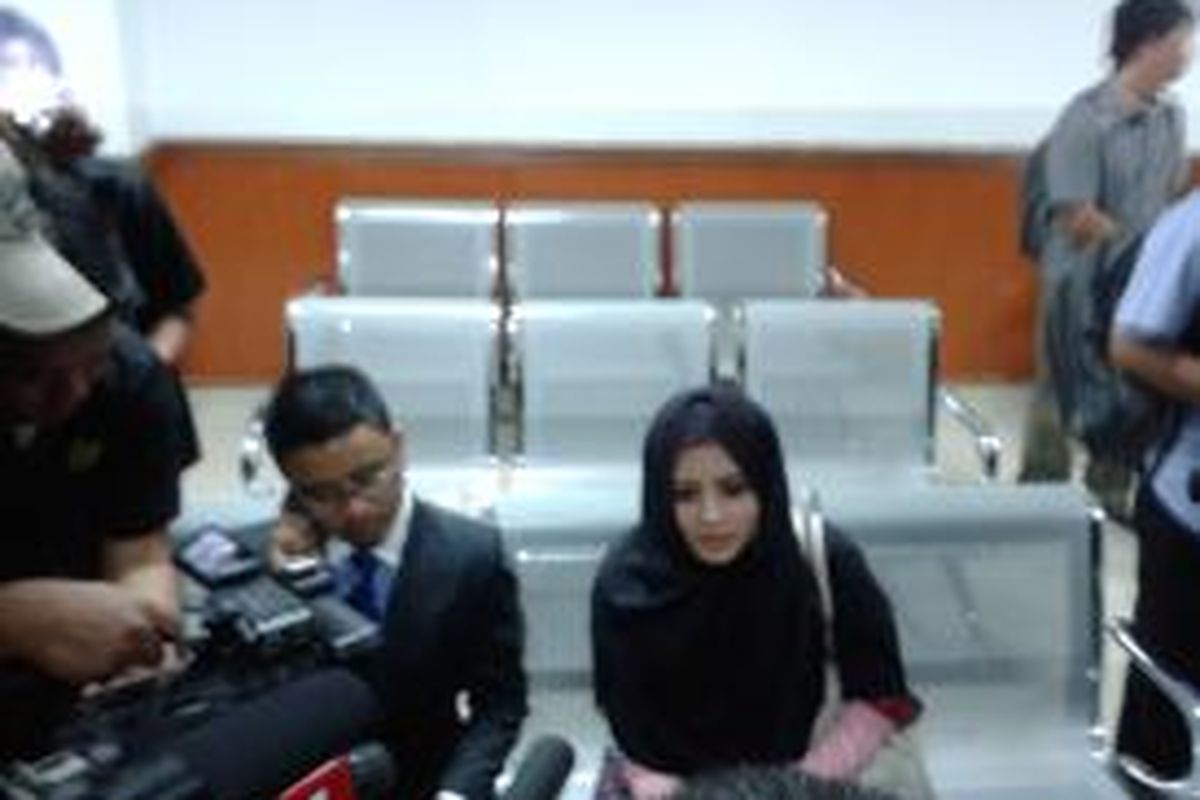 Novi Amalia didampingi kuasa hukumnya Rendy Anggara Putra saat tiba di ruang sidang di Pengadilan Negeri Jakarta Barat, Selasa (16/7/2013)