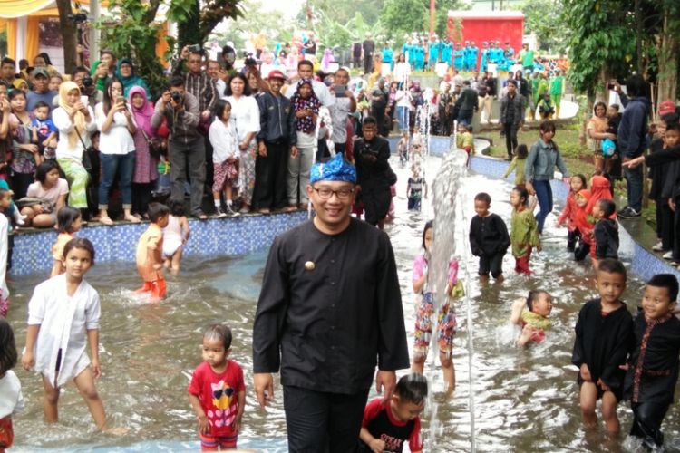 Wali Kota Bandung Ridwan Kamil saat bermain air bersama sejumlah anak kecil dalam acara peresmian Taman Cikapundung Regol, Rabu (7/2/2018).