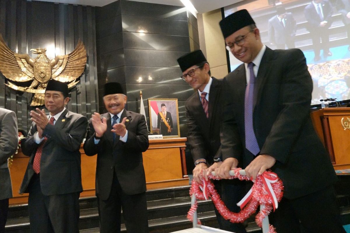 Gubernur DKI Jakarta Anies Baswedan dan Wakil Gubernur DKI Jakarta Sandiaga Uno mendorong troli berisi APBD DKI 2018 yang sudah disahkan dalam sidang paripurna di Gedung DPRD DKI Jakarta, Kamis (30/11/2017). 