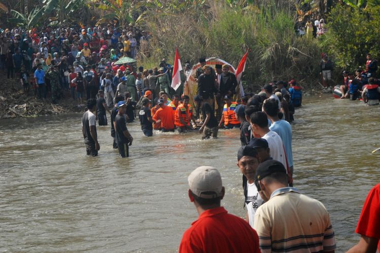 Perwakilan warga Desa Ngombak, Kecamatan Kedungjati, Kabupaten Grobogan, Jawa Tengah menjemput para Perangkat Desa Karanglangu, Kecamatan Kedungjati, Grobogan yang berada di seberang sungai dengan menggunakan rakit yang telah dihias dalam tradisi Asrah Batin di sungai tuntang setempat, Minggu (29/7/2018). Dalam tradisi ini, Kepala Desa dan Perangkat Desa dijemput menggunakan rakit, sementara warga menyeberang sungai dengan berjalan kaki di sungai berarus deras sedalam 70 sentimeter.