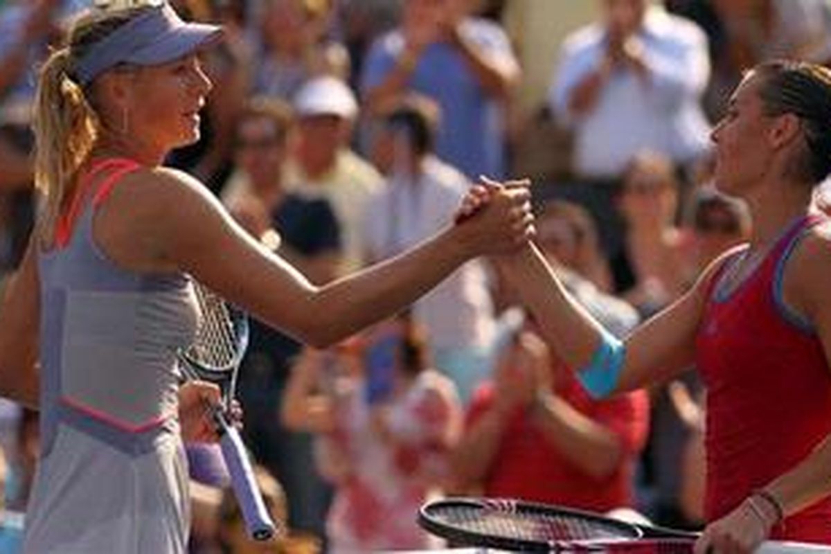 Petenis Flavia Pennetta (kanan) asal Italia menjabat tangan petenis Rusia, Maria Sharapova, seusai pertandingan keduanya di putaran ketiga AS Terbuka di New York, AS, Jumat (2/9/2011). Penneta menang 6-3, 3-6, 6-4.