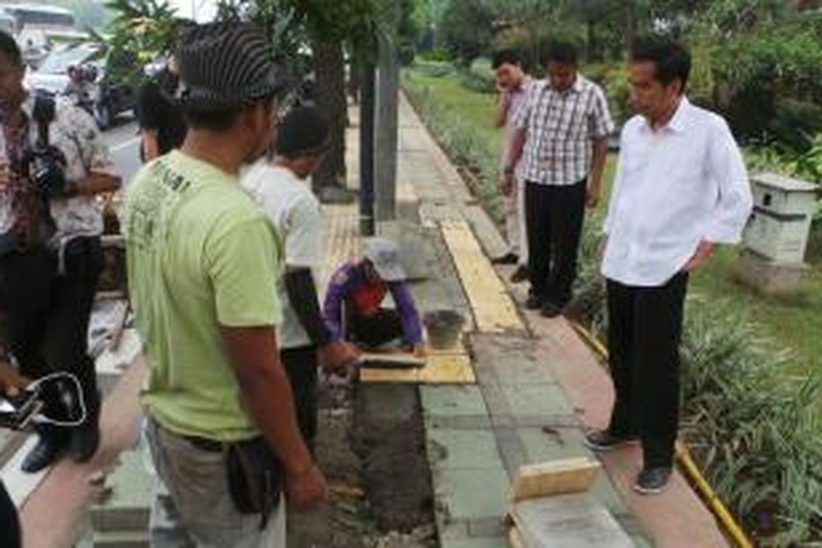 Gubernur DKI Jakarta Joko Widodo (kanan) meninjau perbaikan trotoar Jalan Gatot Subroto, Jakarta Selatan, Sabtu (28/9/2013).