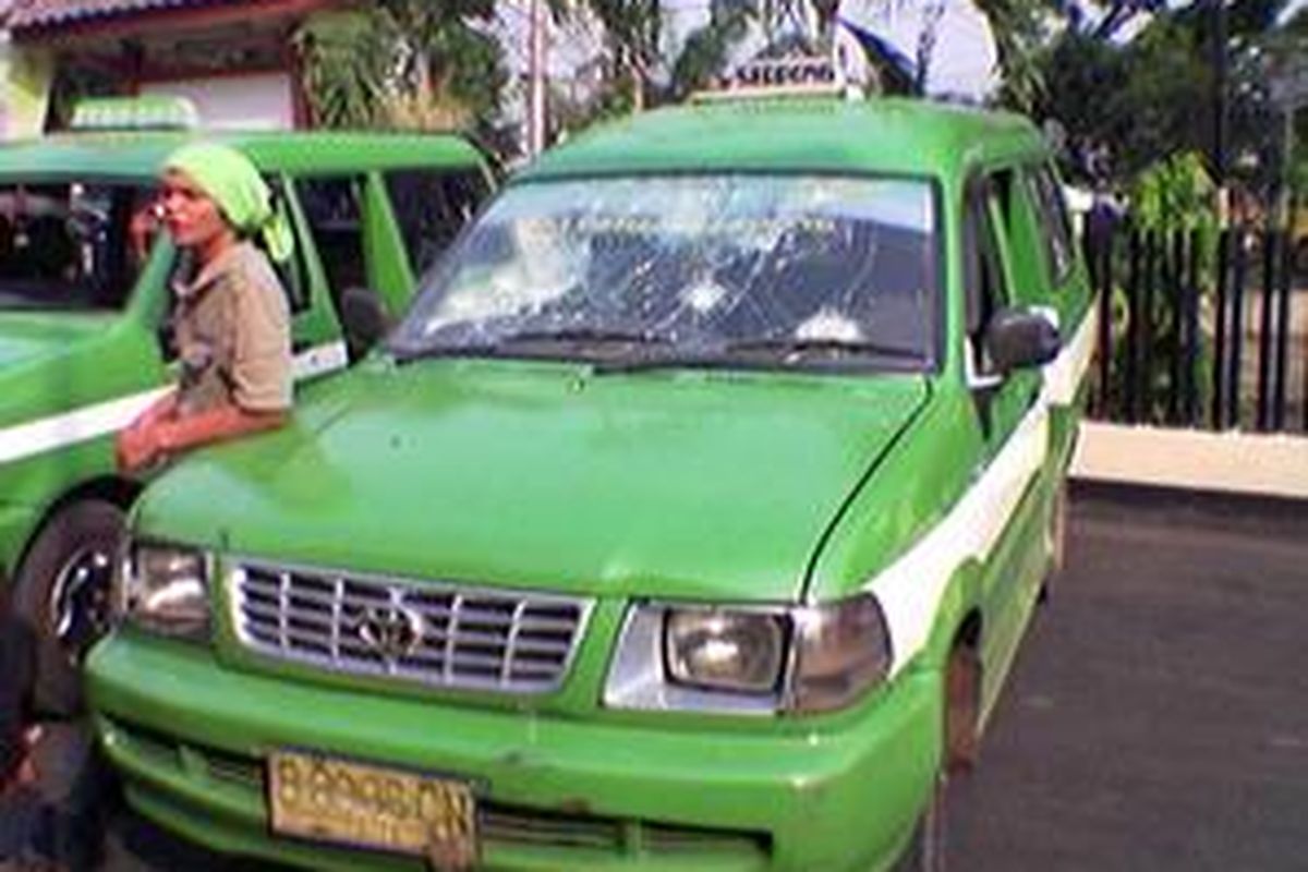 Mobil angkot plat kuning jurusan Serpong-Kalideres yang Senin (28/7) dirusak massa di Kalideres Jakarta Barat. Mobil itu diparkir di Polsek Metro Kalideres.