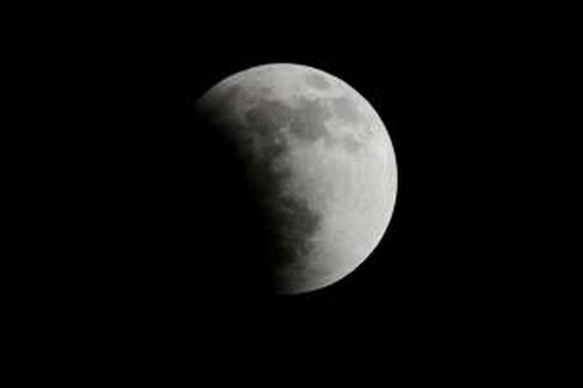 Saat awal terjadinya gerhana bulan terlihat di California, 15 April 2014. Gerhana bulan kali ini terbilang langka karena bulan berubah warna dari oranye ke merah darah.