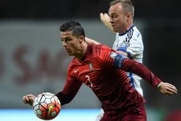 Kapten Portugal, Cristiano Ronaldo (7), berduel dengan pemain belakang Denmark, Lars Jacobsen, saat kedua tim bertemu pada lanjutan kualifikasi Piala Eropa 2016 di Estadio Municipal de Braga, Kamis (8/10/2015). 