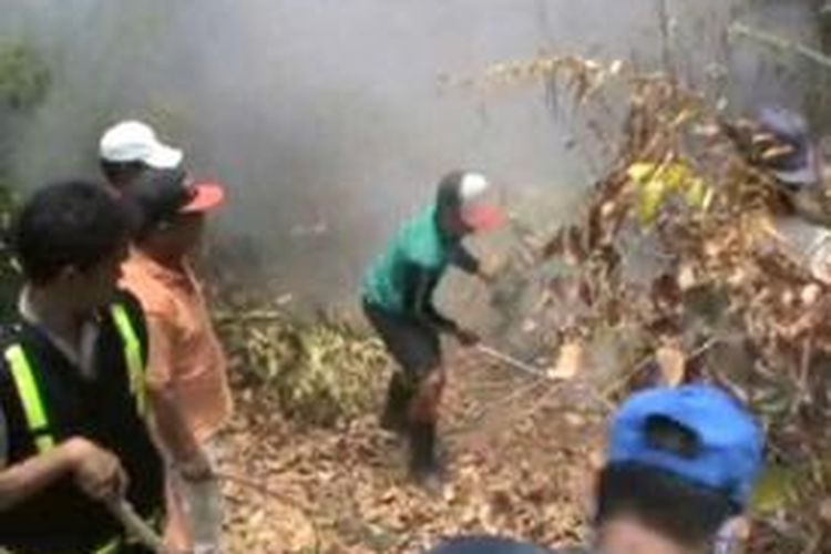 Warga memadamkan api yang membakar kawasan hutan lindung dan perkebunan kakao, durian, duku, dan rambutan di Polewali Mandar sejak tiga hari terakhir. Foto diambil pada Sabtu (17/10/2015).