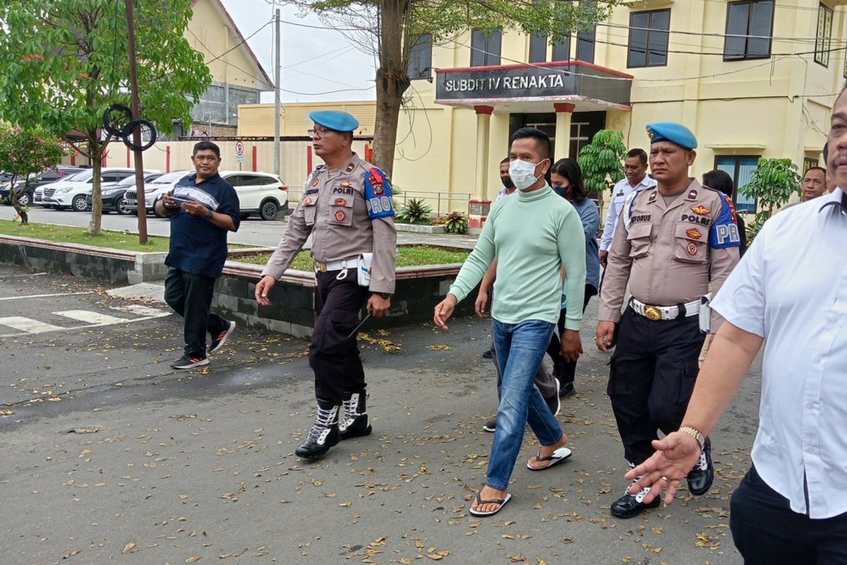 AKBP Achiruddin Hasibuan (kaus hijau) dikawal sejumlah personel polisi saat berjalan menuju gedung Direktorat Reskrimum Polda Sumut untuk diperiksa pada Kamis (27/4/2023) siang.