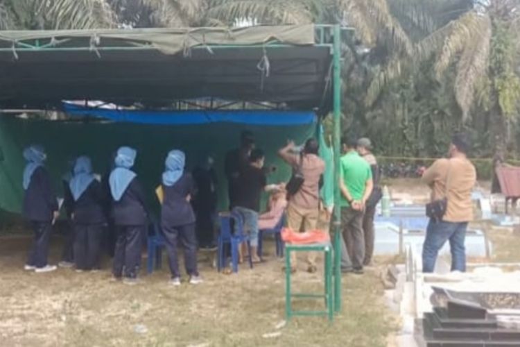 Petugas kepolisian membongkar makam bayi untuk diotopsi di Desa Mahato, Kecamatan Tambusai Utara, Kabupaten Rokan Hulu, Riau, Sabtu (11/12/2021).