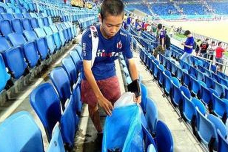 Salah seorang suporter Jepang memungut samapah sesuai Jepang bermain imbang 0-0 dengan Yunani di Estadio das Dunas, Natal, Kamis (19/6/2014). 
