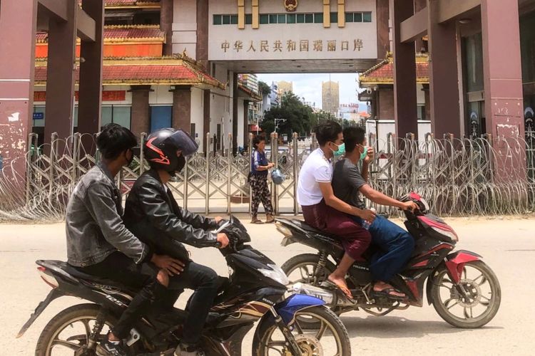 Warga Myanmar naik sepeda motor di dekat perbatasan dengan China di kota Muse, negara bagian Shan, Myanmar.