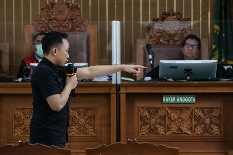 Terdakwa kasus pembunuhan berencana Brigadir J atau Nofriansyah Yosua Hutabarat, Ricky Rizal memeragakan adegan penembakan saat menjalani persidangan di Pengadilan Negeri Jakarta Selatan, Senin (9/1/2022).