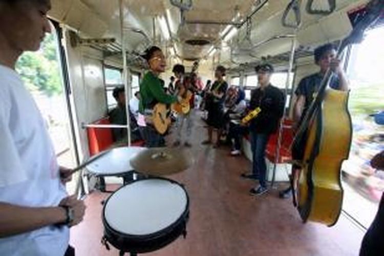 Satu grup pengamen dengan beragam alat musik beraksi di dalam kereta api Commuter Line KRL Ekonomi dari arah Bekasi ke Manggarai, Rabu (21/3/2012).