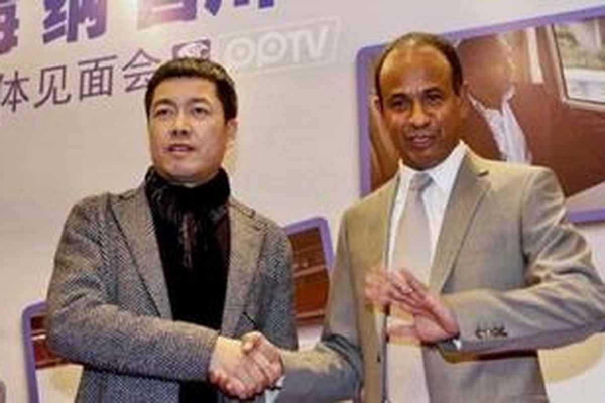 Pelatih asal Perancis, Jean Tigana (kanan) berjabat tangan dengan Direktur Shanghai Shenhua Football Club, Zhou Jun, setelah menandatangani kontrak pelatih di Shanghai, Minggu (18/12/2011).