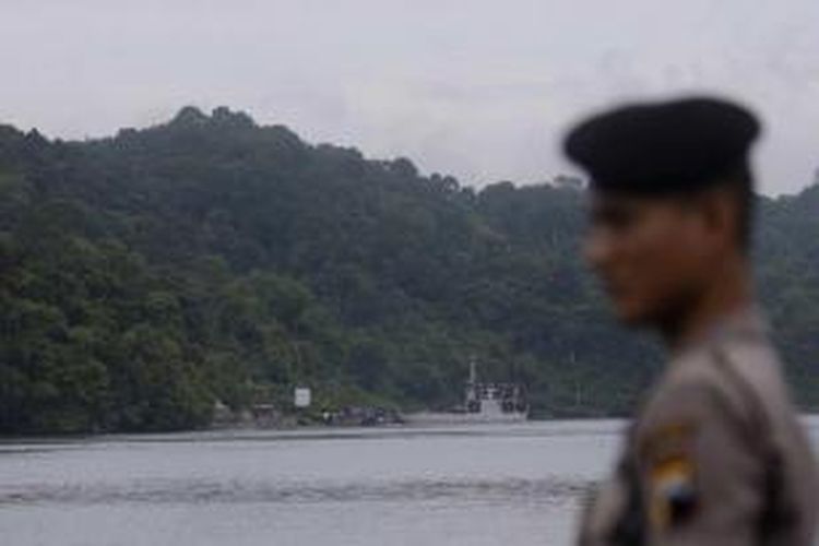 Polisi berjaga dengan latar belakang feri yang membawa dua terpidana mati kasus narkotika kelompok Bali Nine yaitu Andrew Chan dan Myuran Sukumaran, tiba Pulau Nusakambangan, Cilacap, Rabu (4/3/2015).