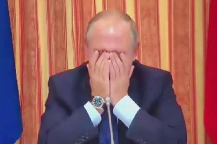 Presiden Rusia Vladimir Putin menutupi wajahnya dengan kedua tangannya sambil menahan tawanya di sidang kabinet Rusia.
