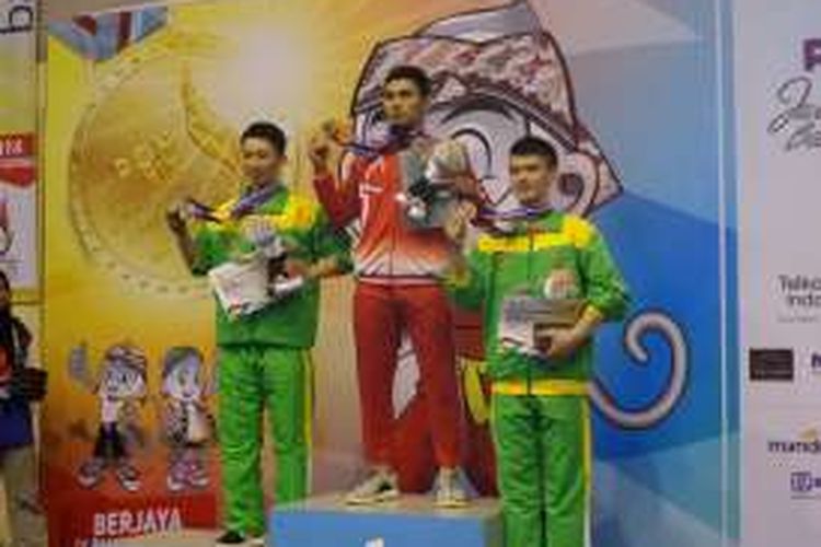 Atlet wushu putra DKI Jakarta, Achmad Hulaefi (tengah), meraih medali emas PON XIX/2016 pada nomor chang quan di GOR Pajajaran, Bandung, Minggu (18/9/2016).