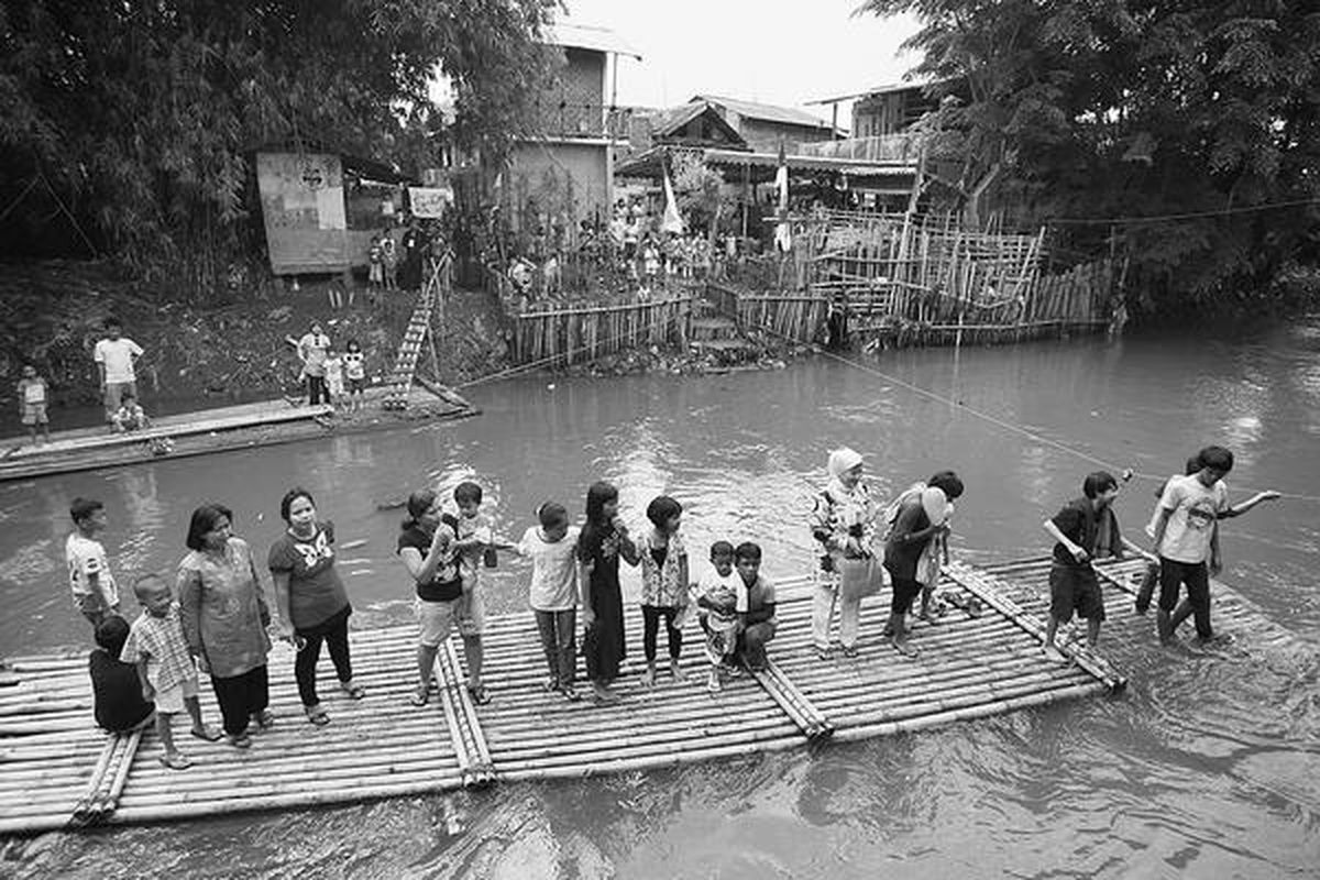 Warga menaiki rakit untuk memeriahkan pasar rakyat yang digelar di sepanjang bantaran Kali Ciliwung di Bukit Duri, Tebet, Jakarta Selatan, Jumat (19/12). Pasar rakyat diramaikan dengan tiga panggung pertunjukan tari dan musik yang digelar hingga Minggu (21/12).  