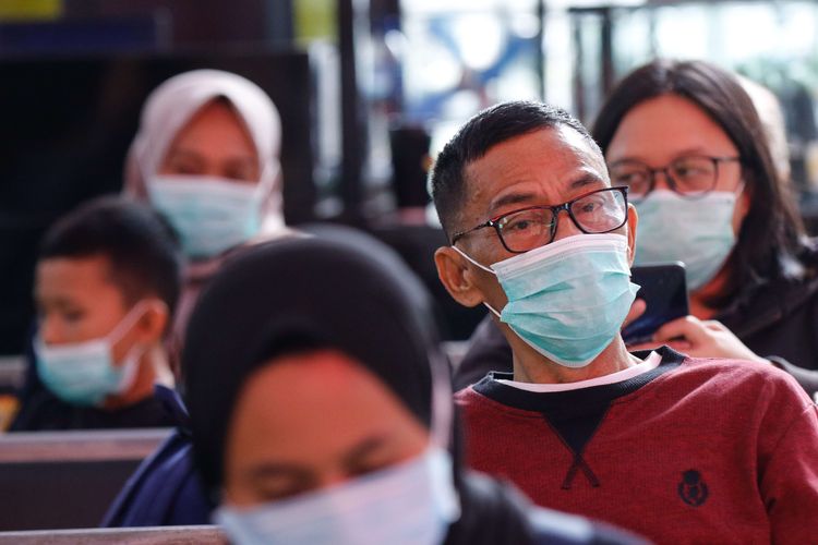 Calon penumpang kereta api mengenakan masker di Stasiun Gambir, Jakarta, Jumat (31/1/2020). PT KAI Daop 1 Jakarta membagikan masker gratis pada calon penumpang dalam rangka mengantisipasi penyebaran virus corona.