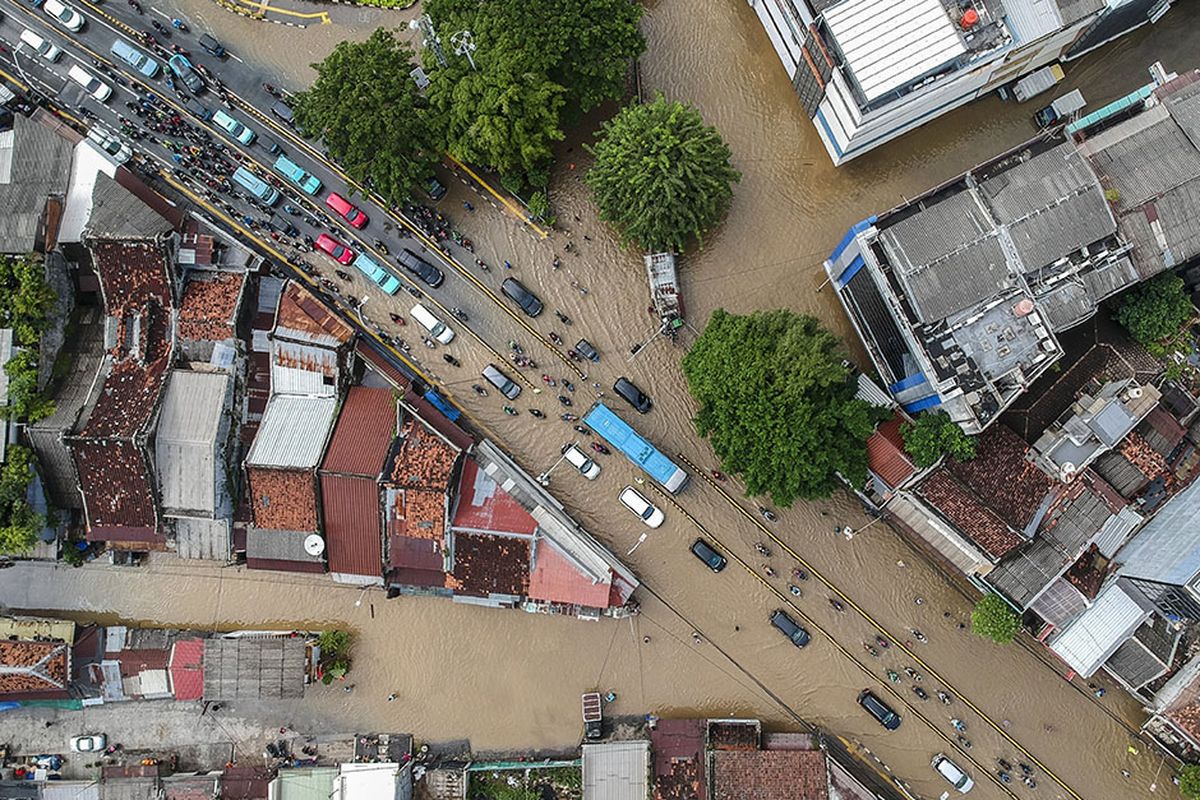 Foto aerial kendaraan melintasi banjir di Jalan Jatinegara Barat, Kampung Pulo, Jakarta, Senin (8/2/2021). Tingginya intensitas hujan mengakibatkan sejumlah wilayah di ibu kota terendam banjir.