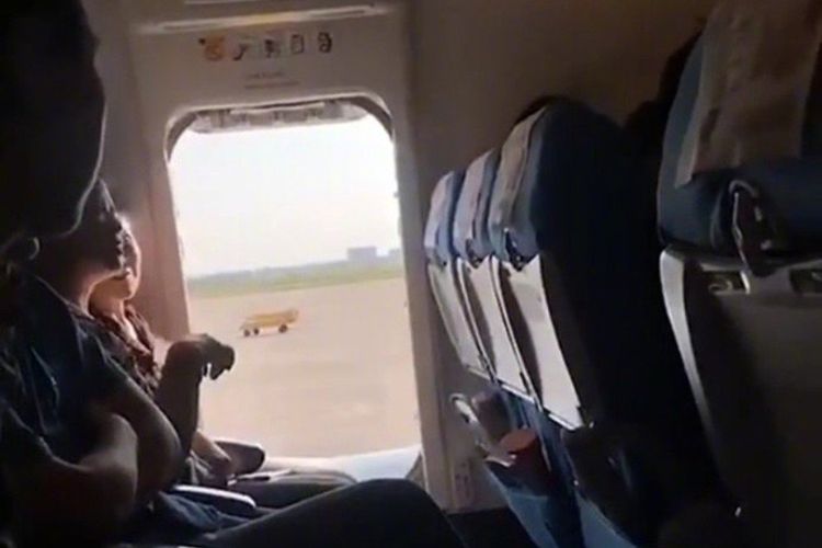 Pintu pesawat yang dibuka oleh penumpang pesawat di Cina untuk mencari udara segar