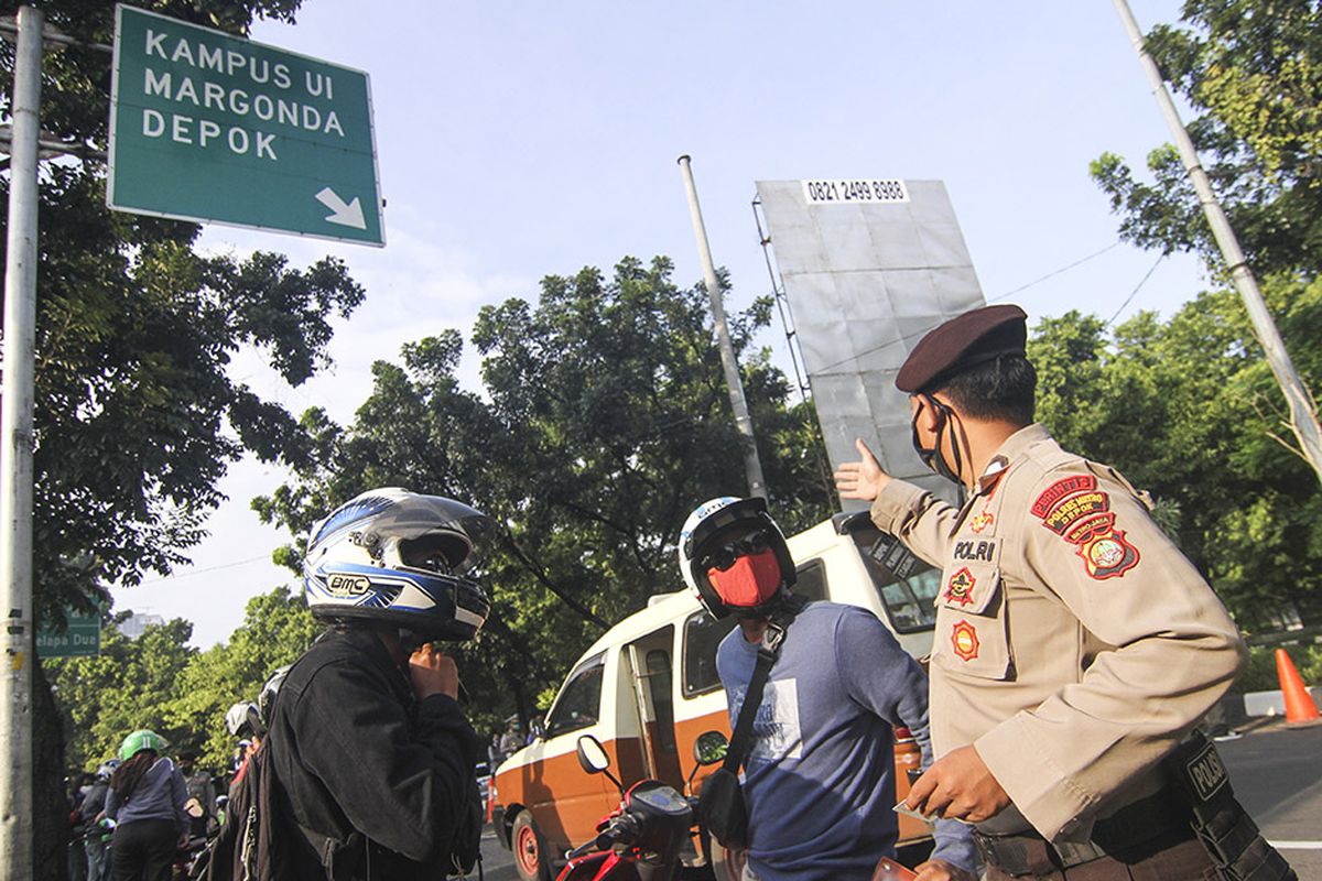 Petugas kepolisian memeriksa pengendara motor yang berpenumpang saat penerapan PSBB di perbatasan Jakarta - Depok, Depok, Jawa Barat, Rabu (15/4/2020). Pemeriksaan tersebut untuk memastikan setiap pengendara mematuhi aturan Pembatasan Sosial Berskala Besar (PSBB) yang diterapkan di Kota Depok.