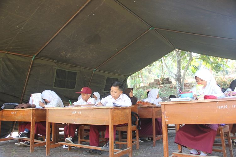 Suasana siswa SDN Pancawangi Cilaku, Cianjur, Jawa Barat yang tengah belajar di bawah tenda tentara setelah dua bulan mereka belajar di halaman sekolah dan kepanasan..